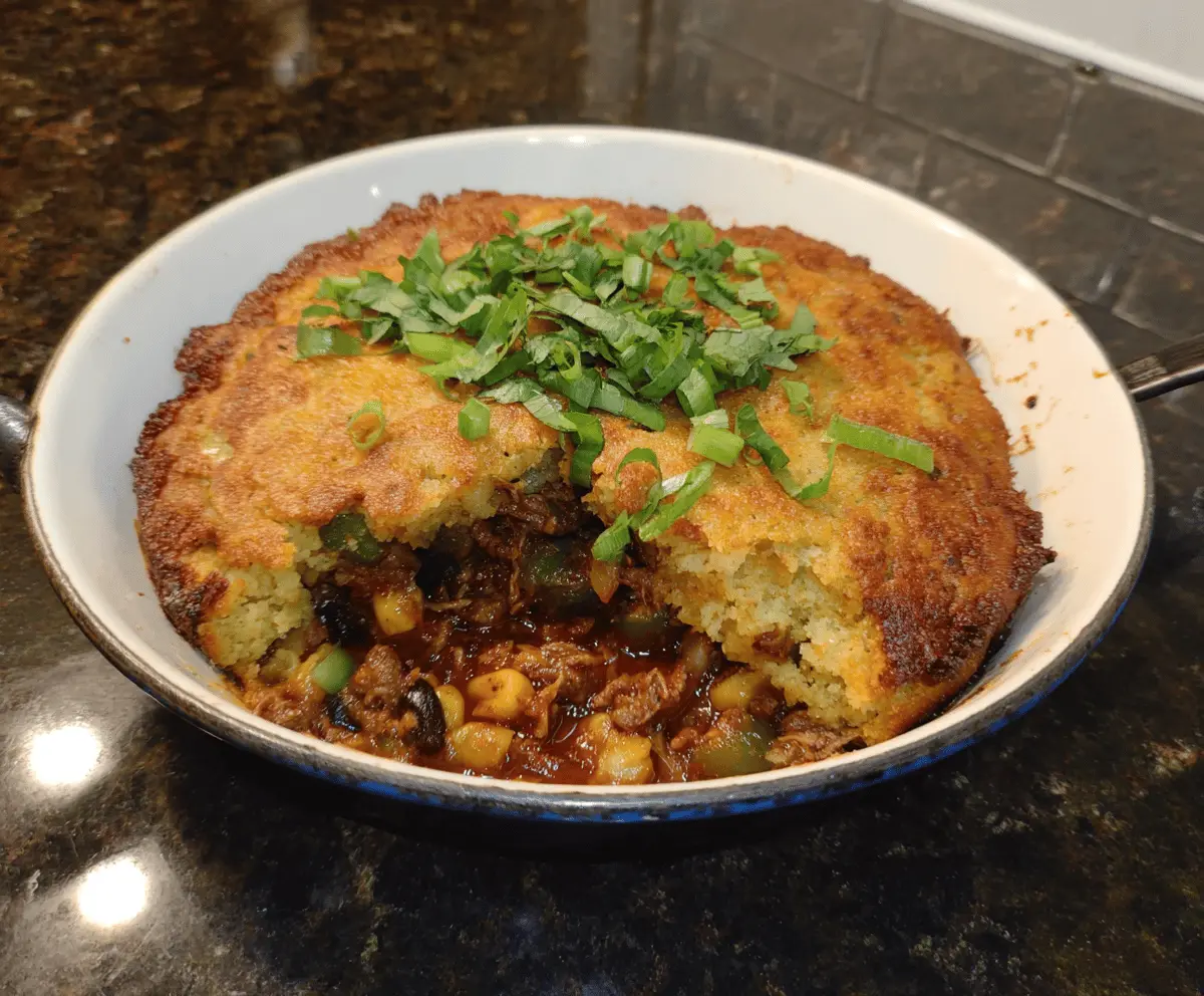 Delicious BBQ Tamale Pie topped with melted cheese and fresh herbs