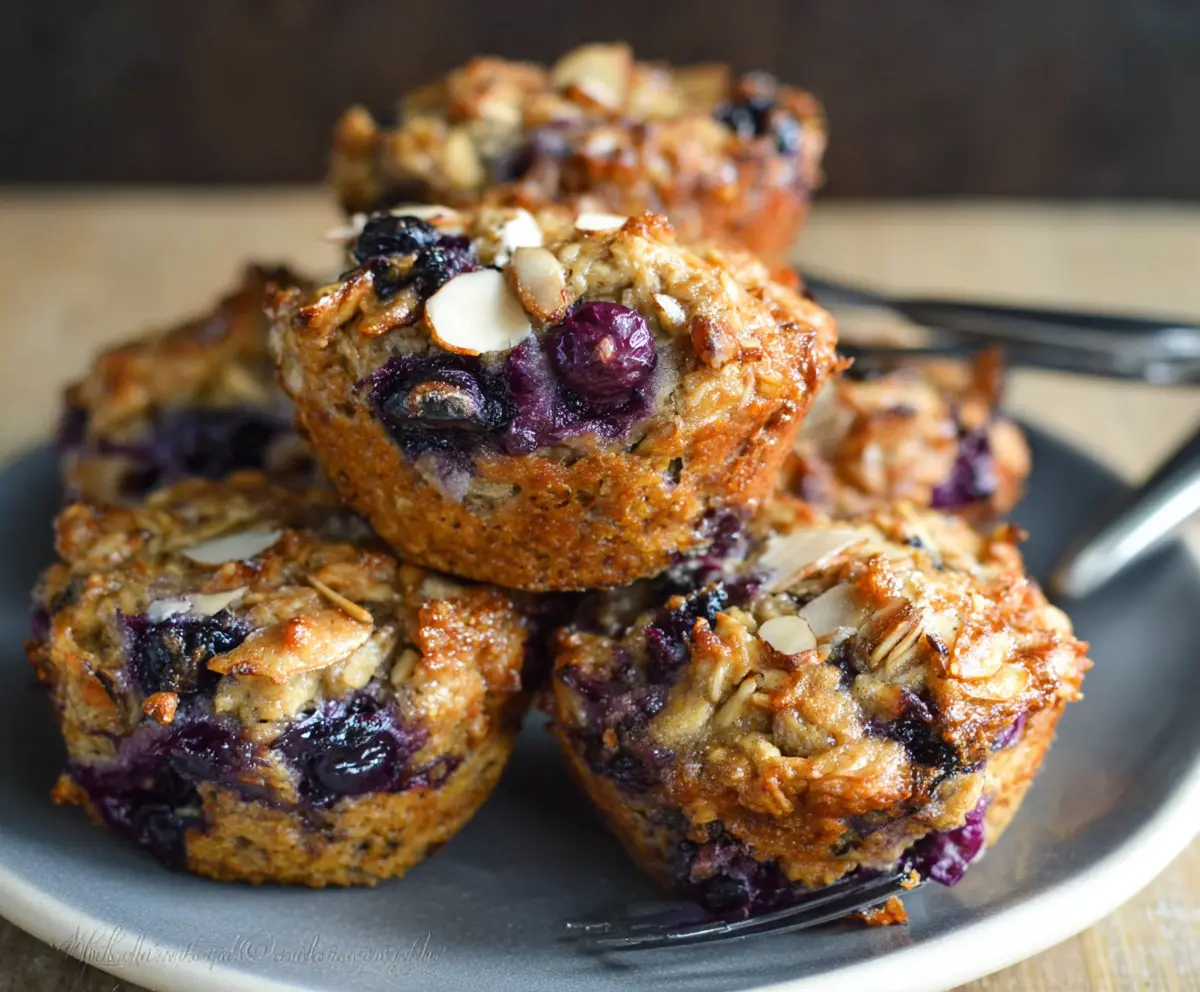 Fresh Blueberry, Pear, and Ginger Oatmeal Muffins arranged on a white plate for a healthy breakfast.