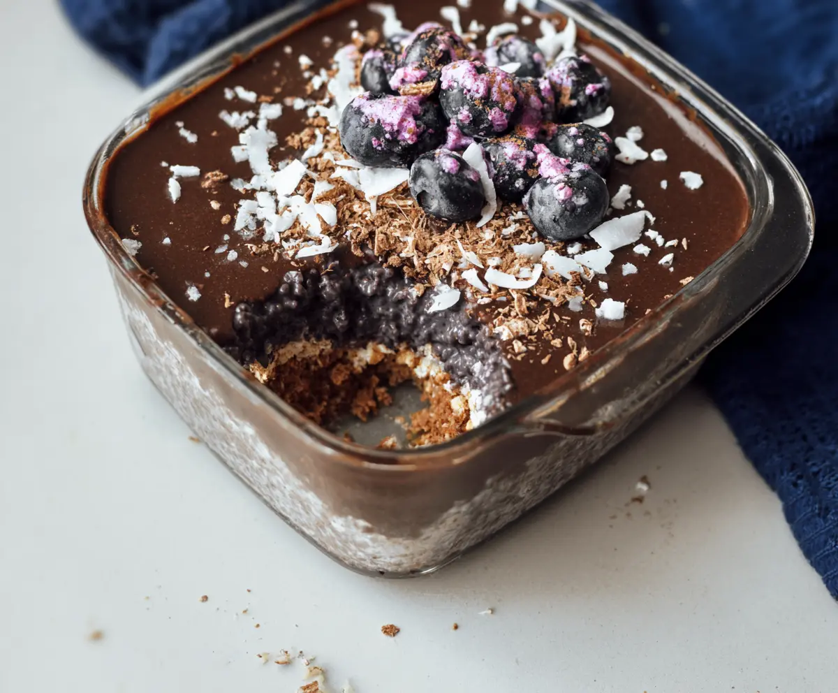 Delicious Chocolate Coconut Blueberry Overnight Weetbix in a bowl with fresh berries and shredded coconut
