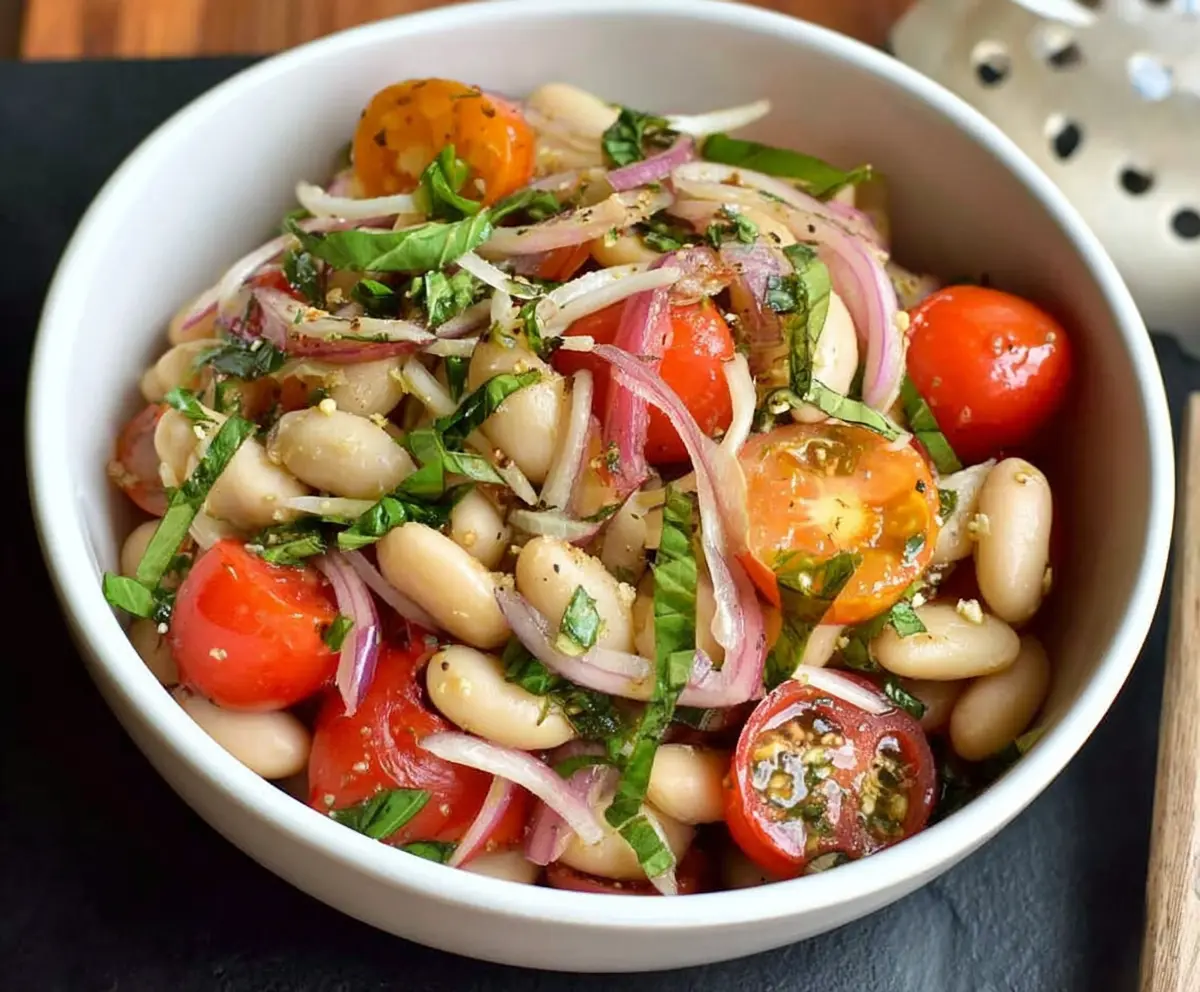 Fresh Italian White Bean Salad with cherry tomatoes and basil in a bowl, ideal for a healthy meal.
