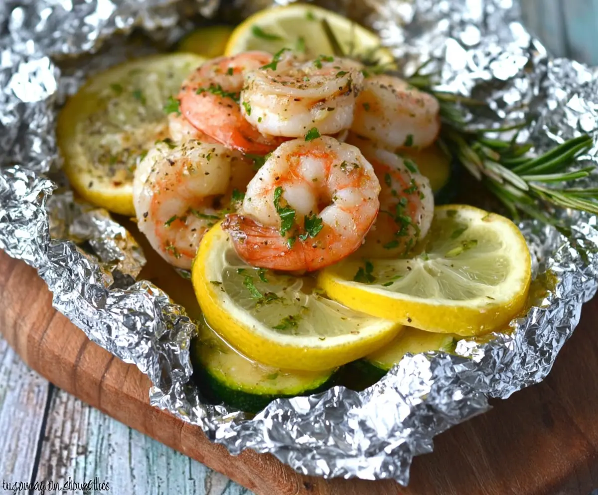 Delicious Low Carb Shrimp Scampi served in a foil packet with fresh herbs and lemon slices.